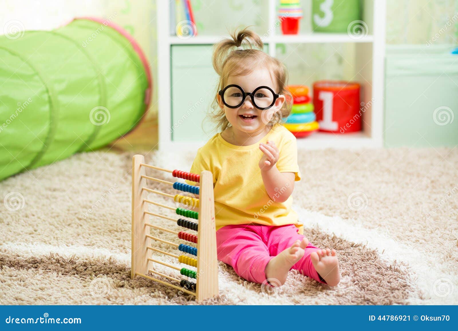 kid weared eyeglasses playing with abacus