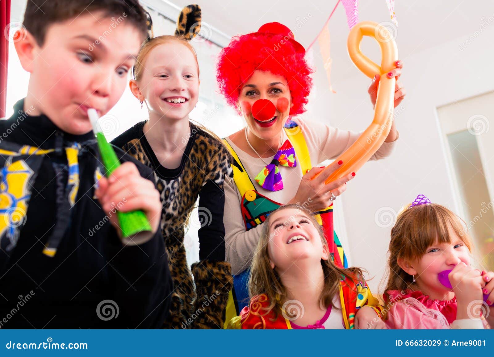 Kids birthday party with clown and lot of noise. Children celebrating birthday party with noisemakers while a clown is visiting entertaining the kids