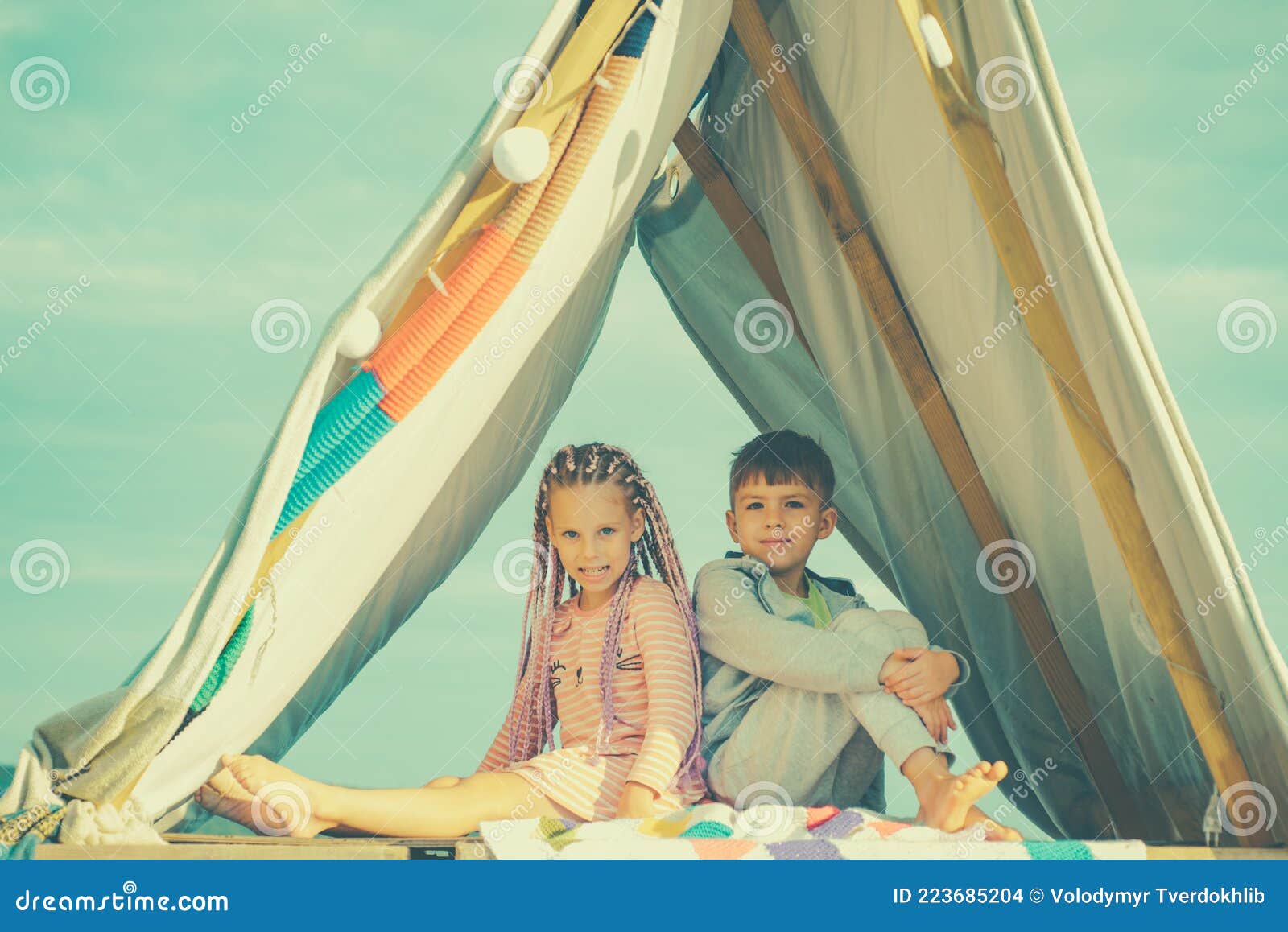 Sisters spending time in a tent on camping. Children using tablet playing games  online during summer vacation - a Royalty Free Stock Photo from Photocase