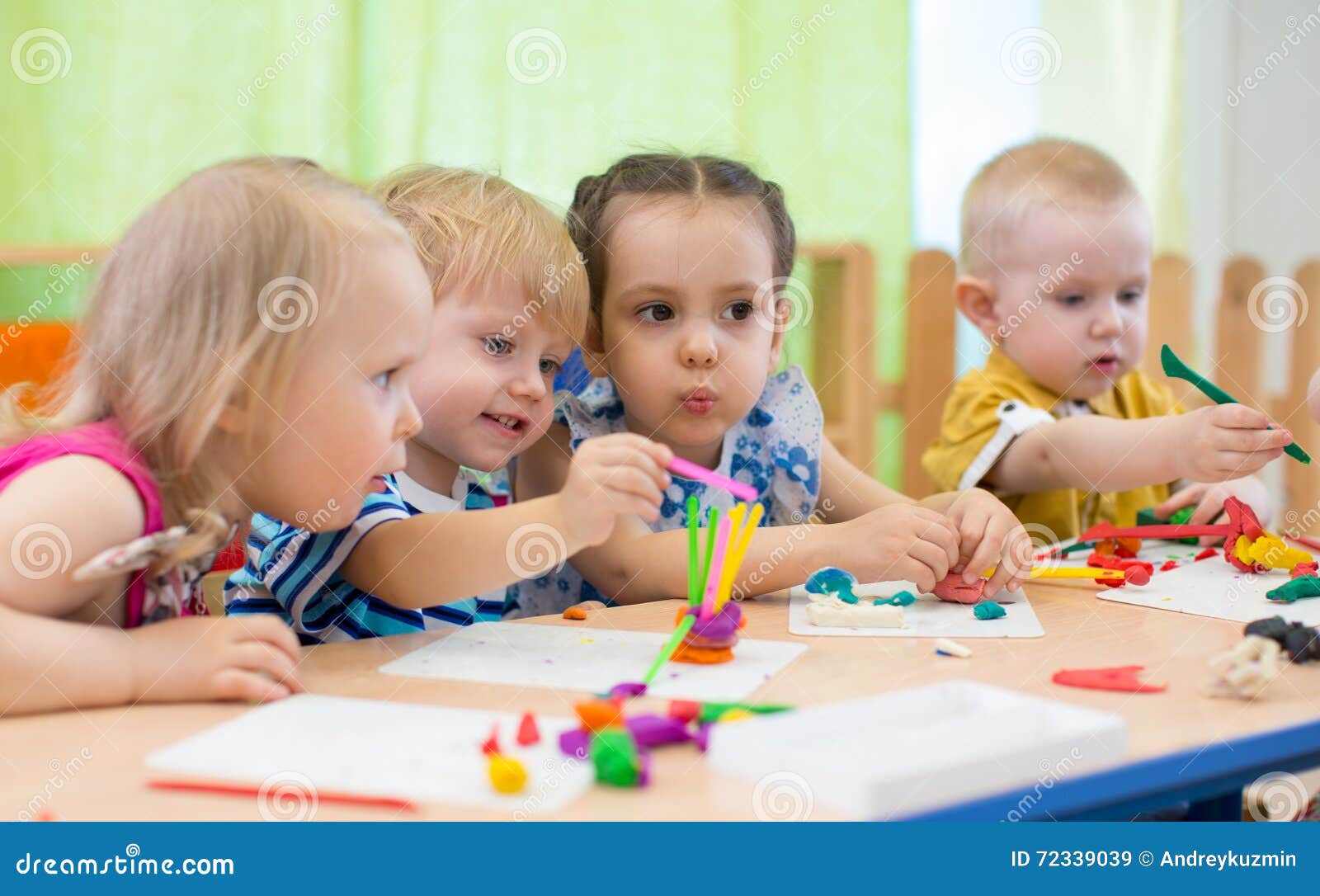 kids group making arts and crafts in kindergarten. children spending time in day care centre with the great interest.