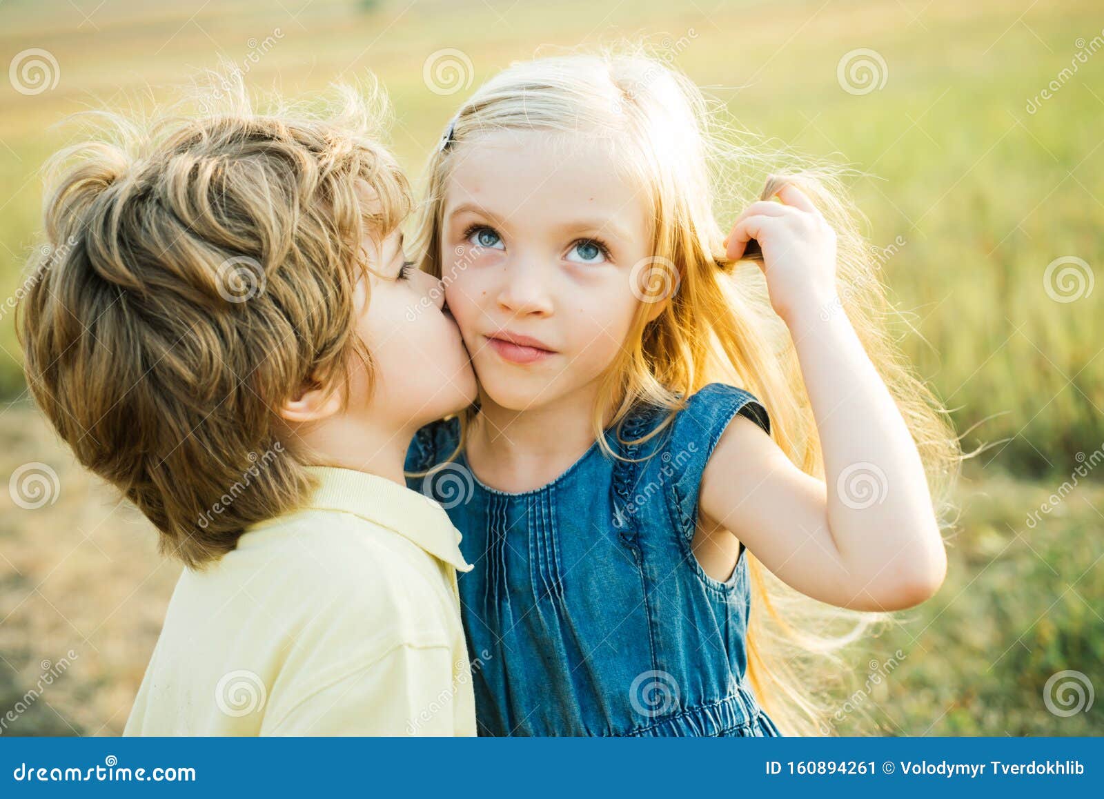 kids having fun in green field against blue sky background. festive art greeting card. lovely children. little angels in