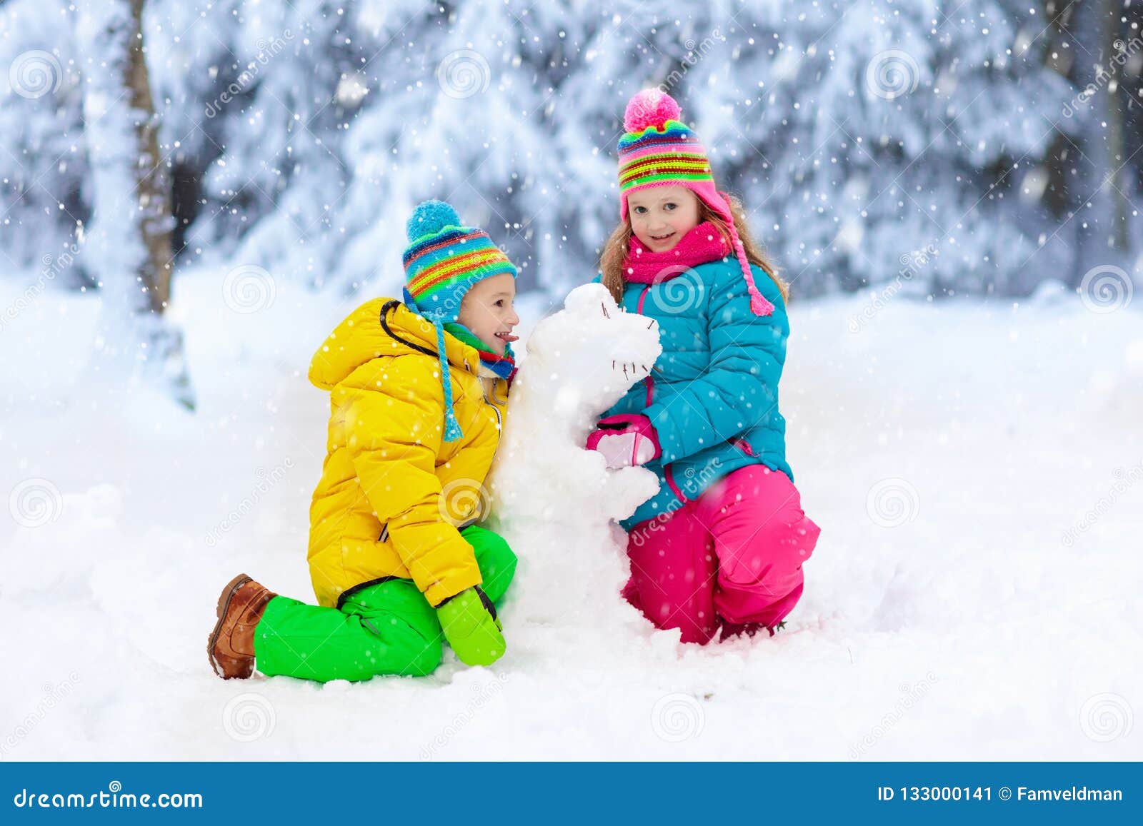 kids making winter snowman. children play in snow