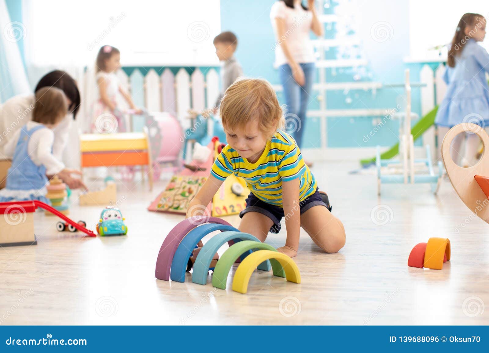 kids play on floor with educational toys. toys for preschool and kindergarten. children in nursery or daycare