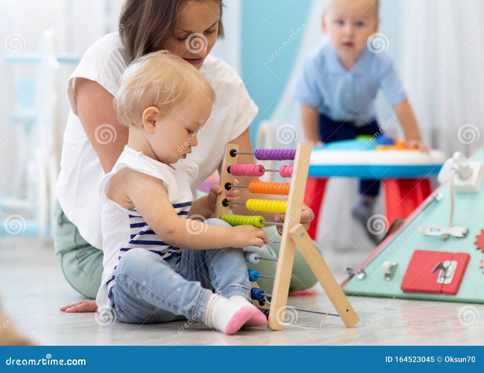 kids playing on floor with educational toys in kindergarten. children have fun in nursery or daycare. babies with