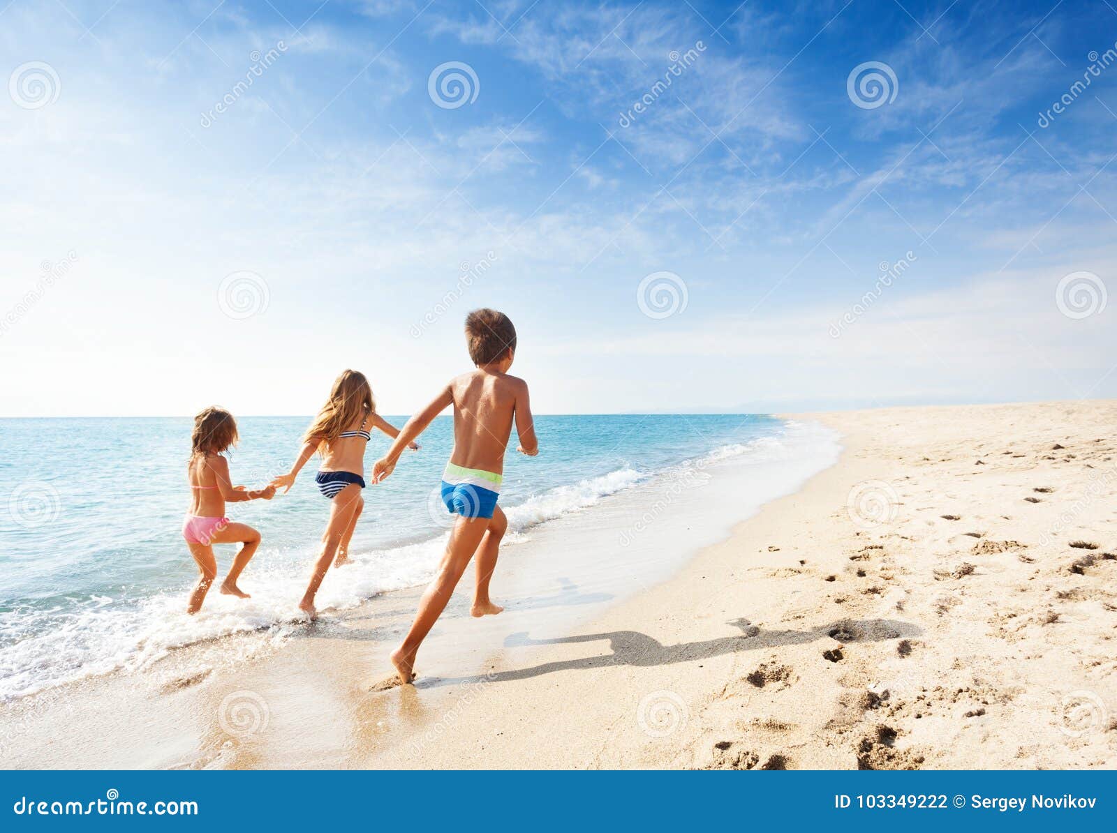 kids running along beach during summer vacation