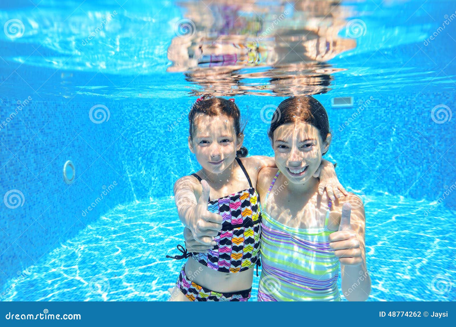 kids swim in pool underwater