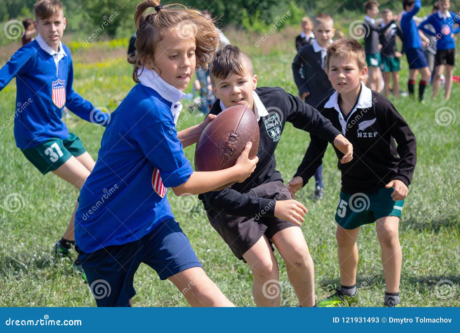 Un Tableau D'enfants Courant Avec Un Ballon De Rugby.