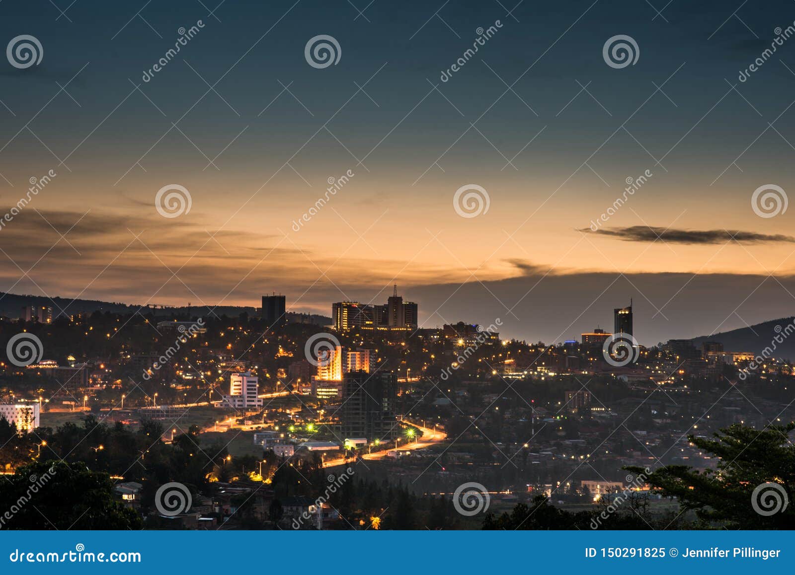 kigali city centre skyline and surrounding areas lit up at dusk. rwanda