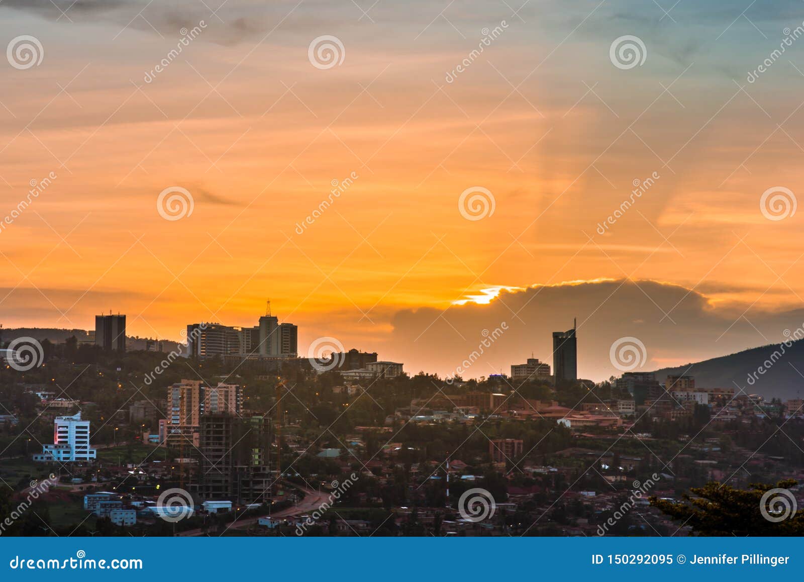 kigali city centre skyline and surrounding areas under colorful clouds at sunset. rwanda