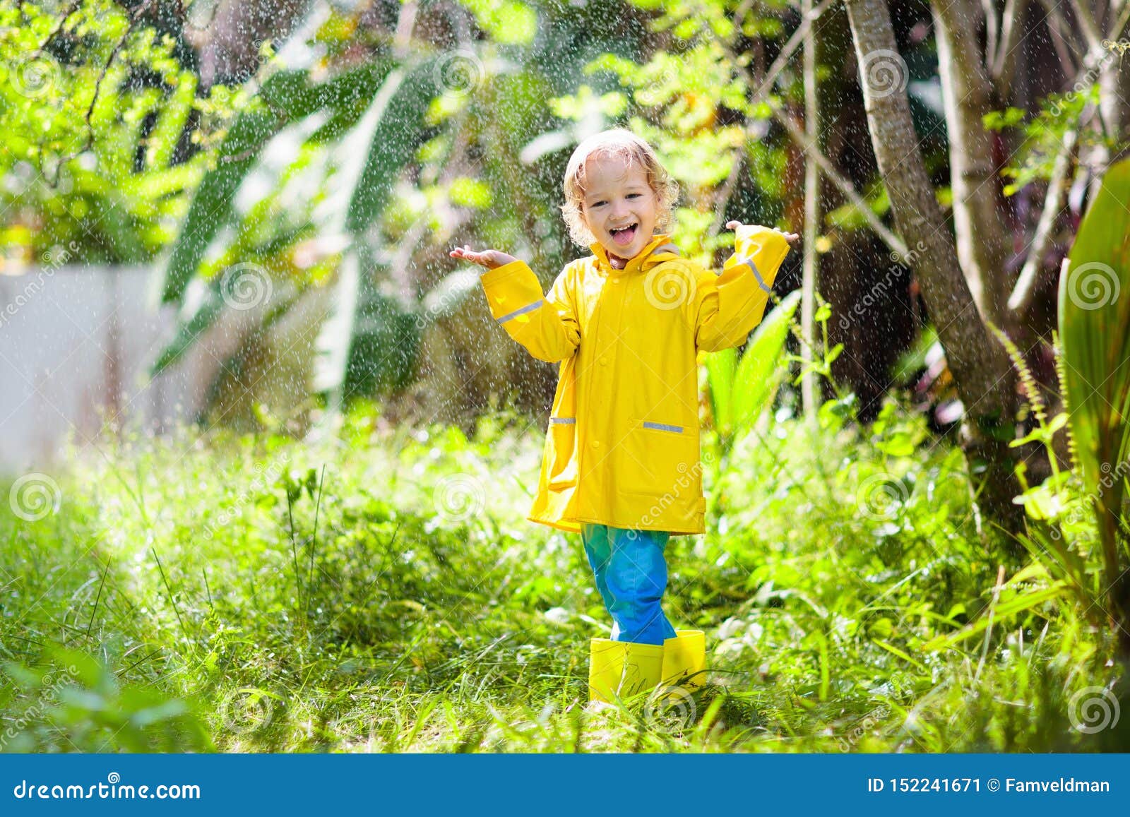 kind das im regen spielt kind mit regenschirm stockbild