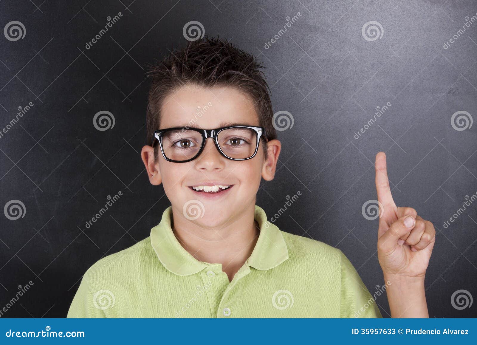 Kind in der Schule. Kinderin der schule glückliches Lächeln mit dem Finger angehoben, um zu antworten