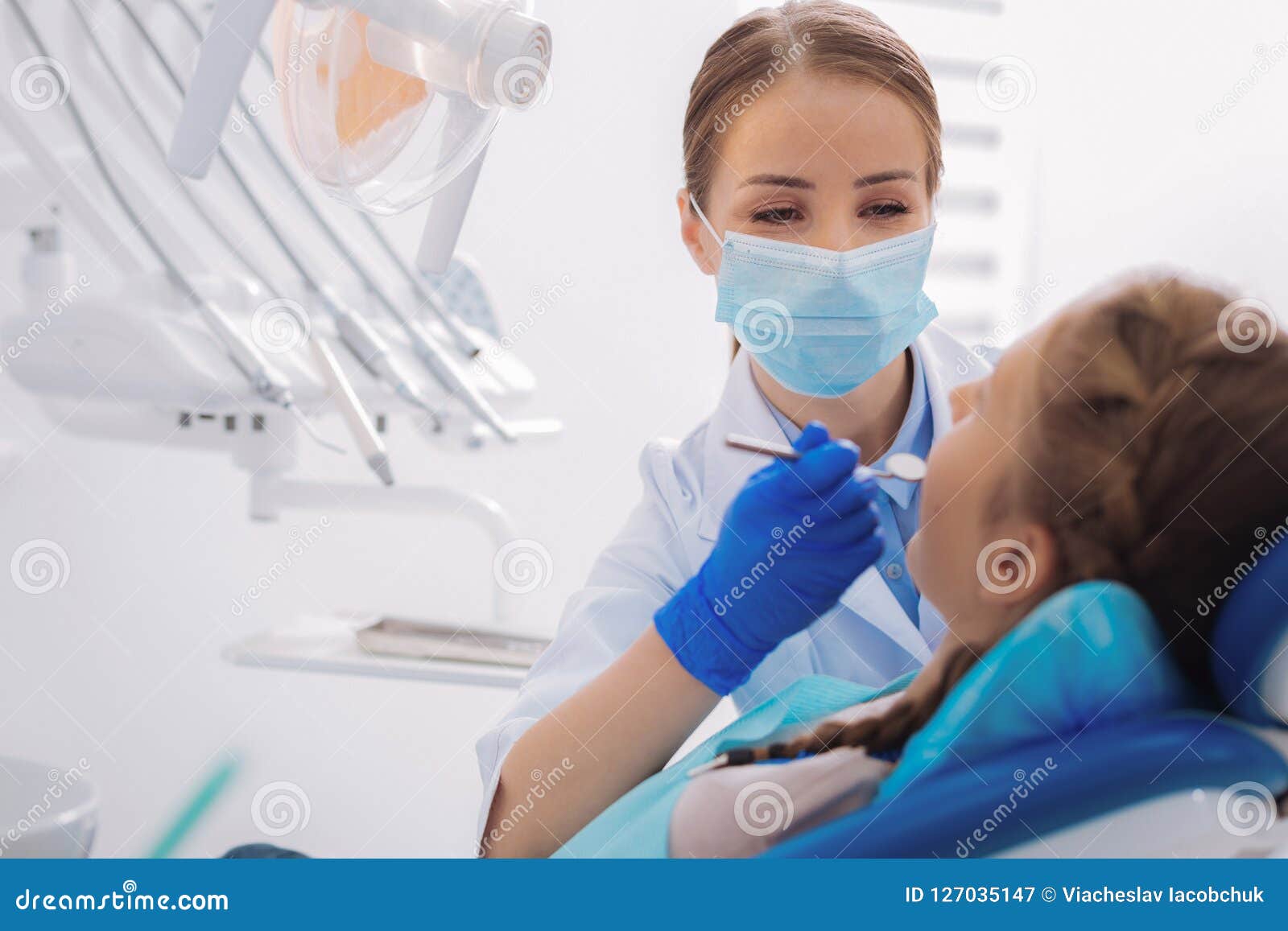 kind orthodontist holding a dental mirror while working