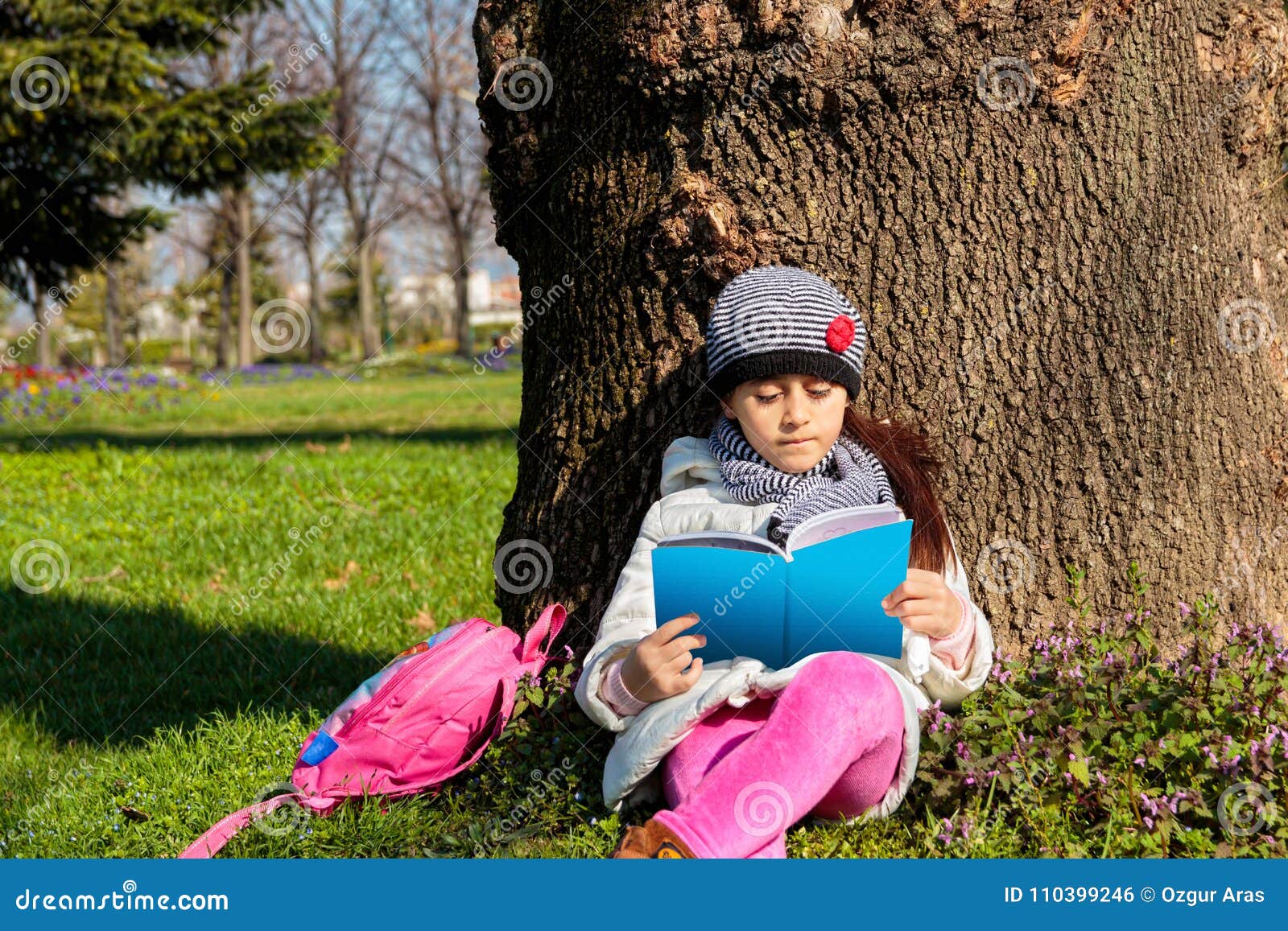 Kind, welches draußen das Buch im Park liest