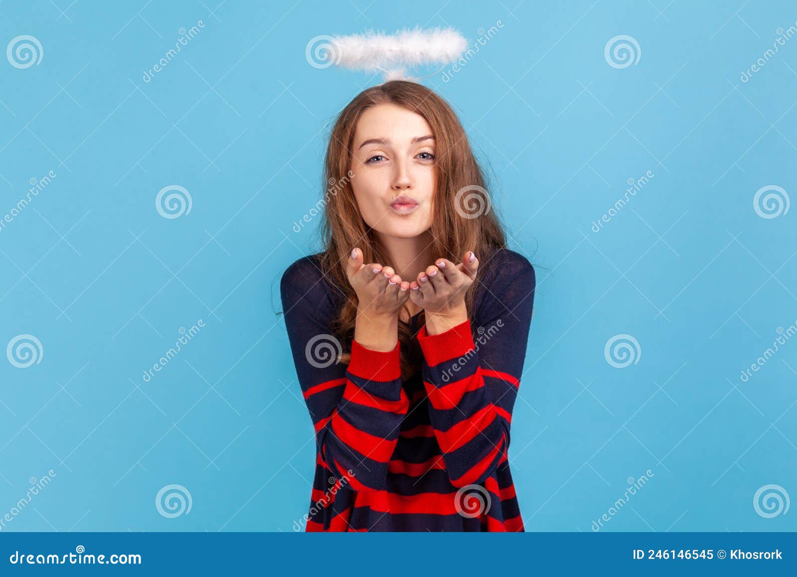 woman with nimb over head sending air kiss over palms, expressing fondness, romantic feelings.