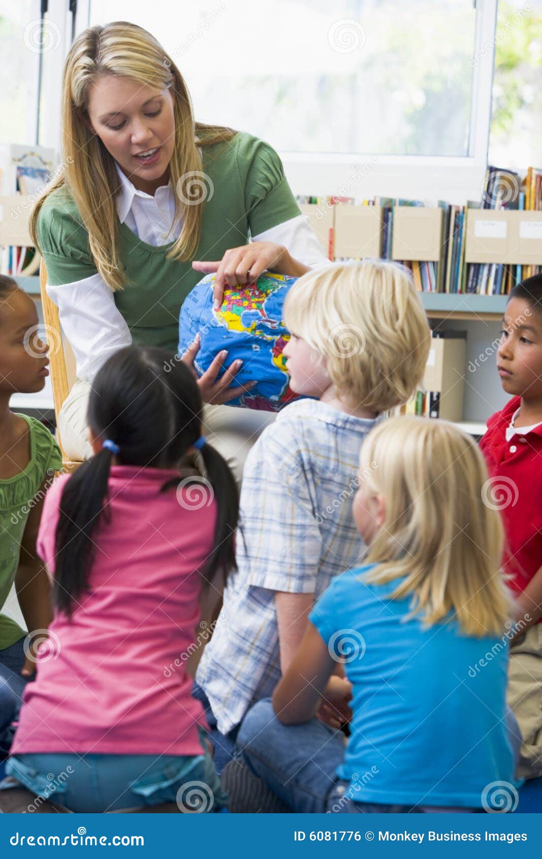 Kindergarten Teacher and Children Looking at Globe Stock Photo Image