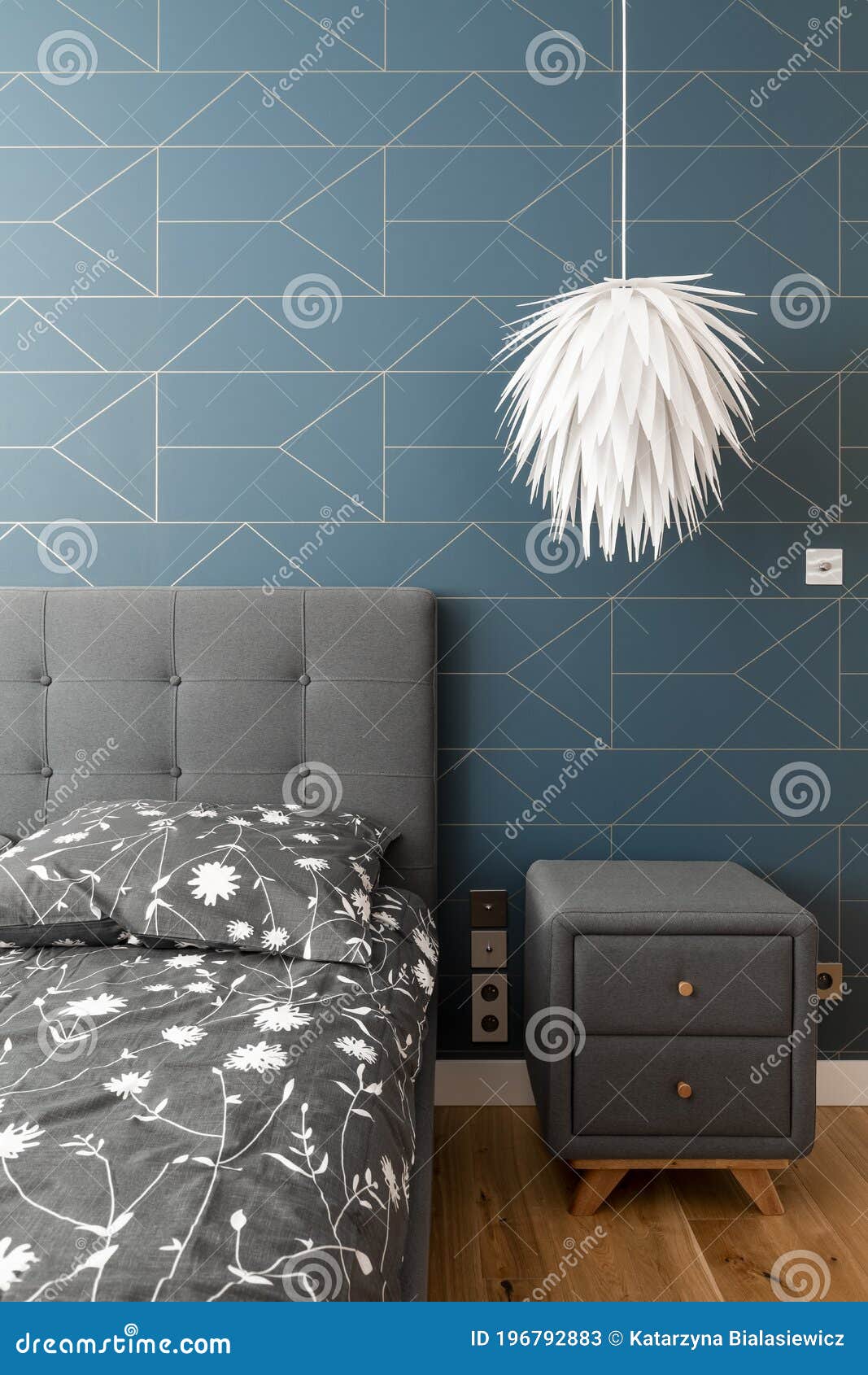 Bed with Patterned Bedding, White Lamp Grey Nightstand Stock Image
