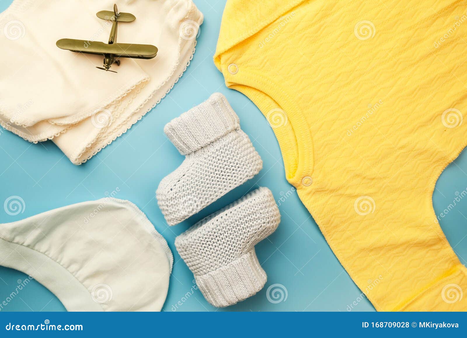 Newborn baby boy clothes. Flatlay design. Kit of dress for baby boy on blue background. Flatlay design.