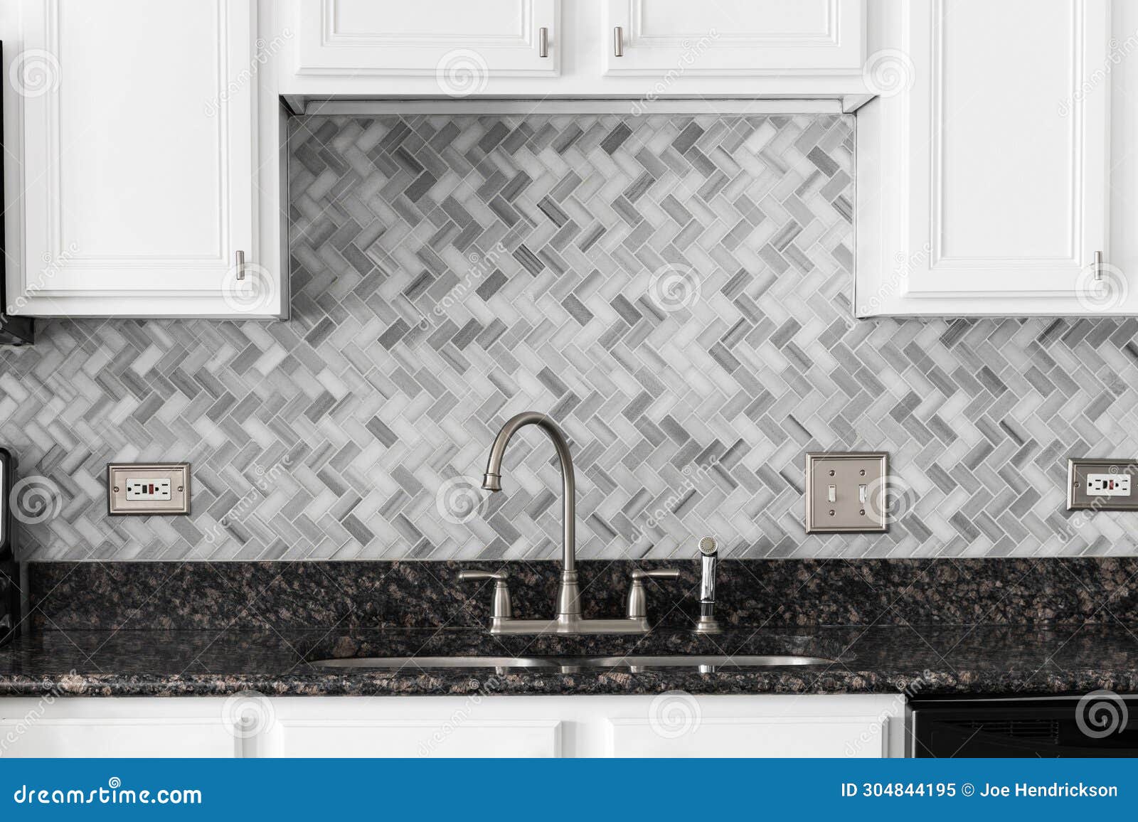 A Kitchen Faucet Detail with White Cabinets and Herringbone Tile ...