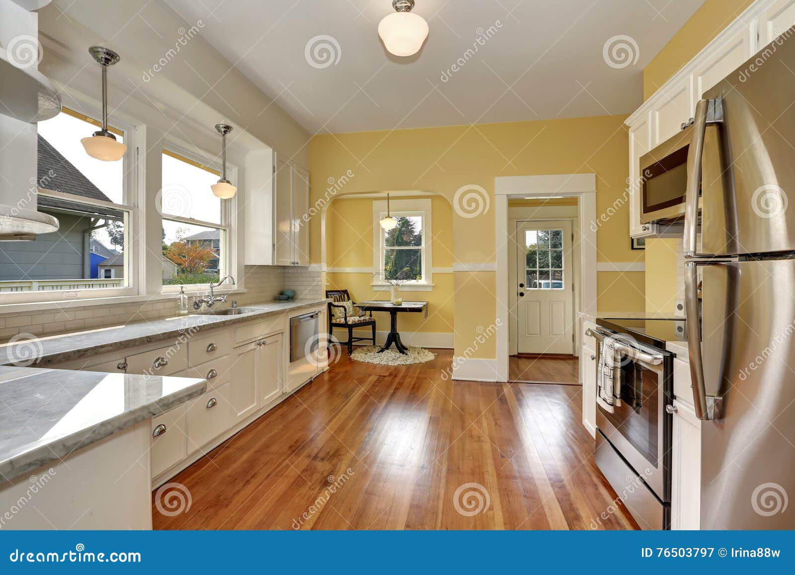 Kitchen Interior With White Cabinets Yellow Walls And Wood Floor