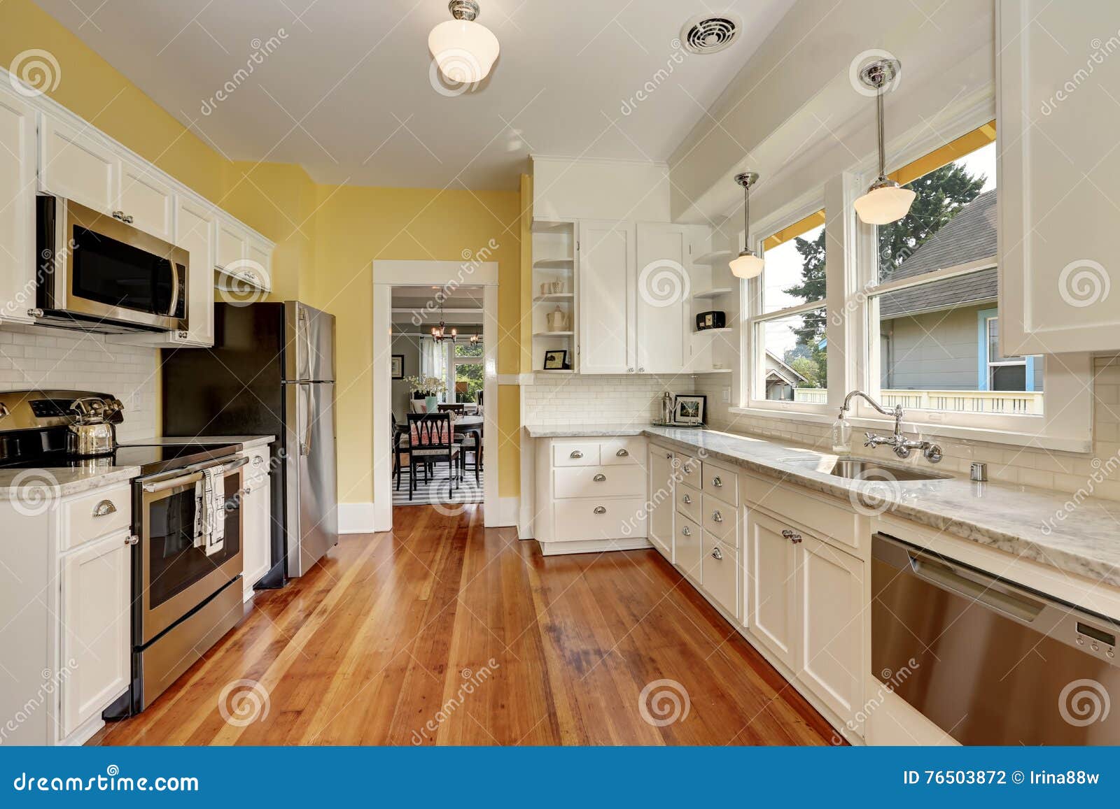 Kitchen Interior With White Cabinets Yellow Walls And Wood Floor