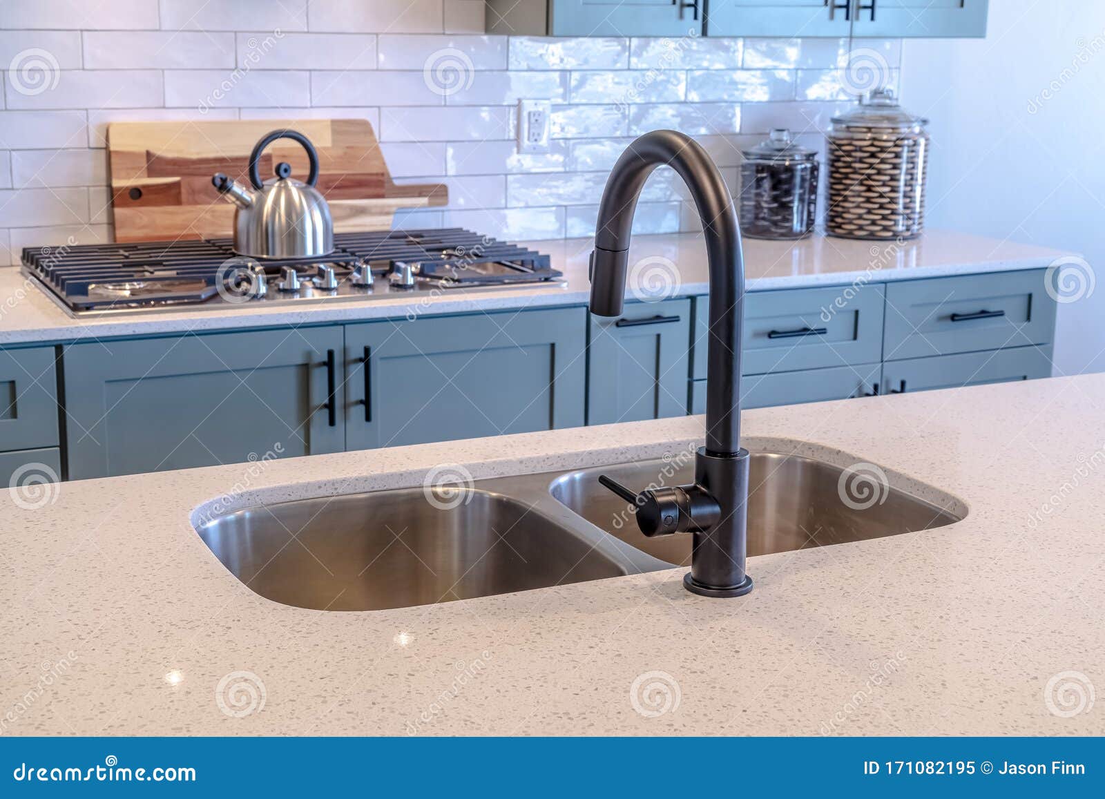 Kitchen Island Double Sink and Black Faucet Against Cooktop and Tile ...