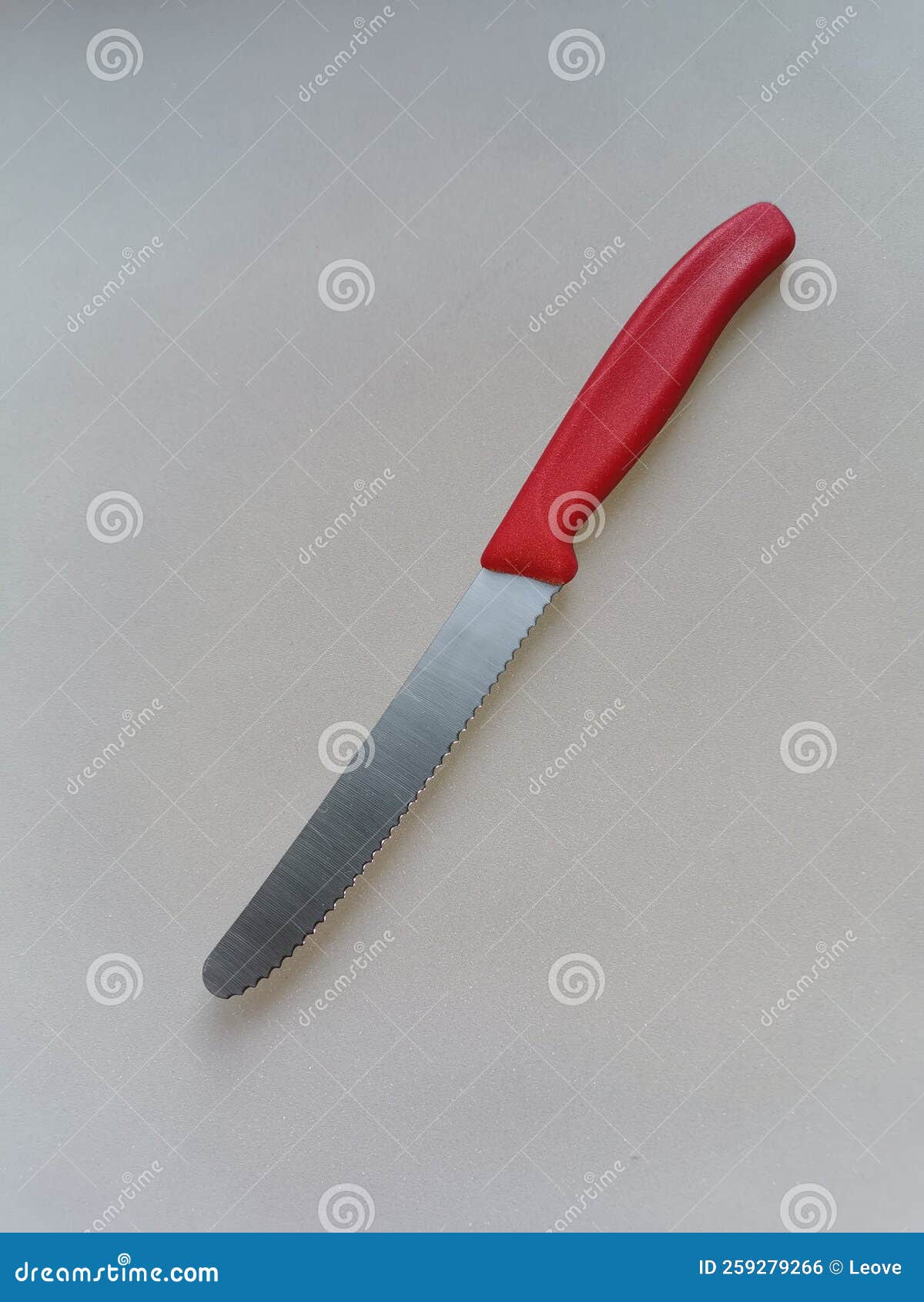 A Kitchen Knife, with a Serrated Blade and a Red Plastic Handle Stock