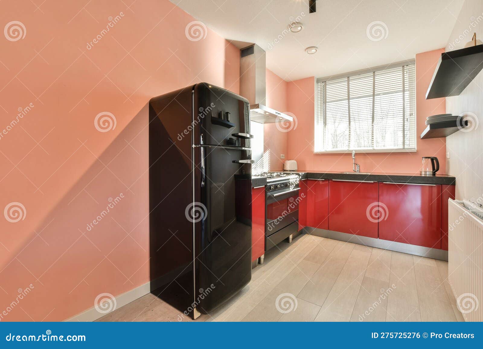 A Kitchen with Red Cabinets and a Black Refrigerator Stock Photo