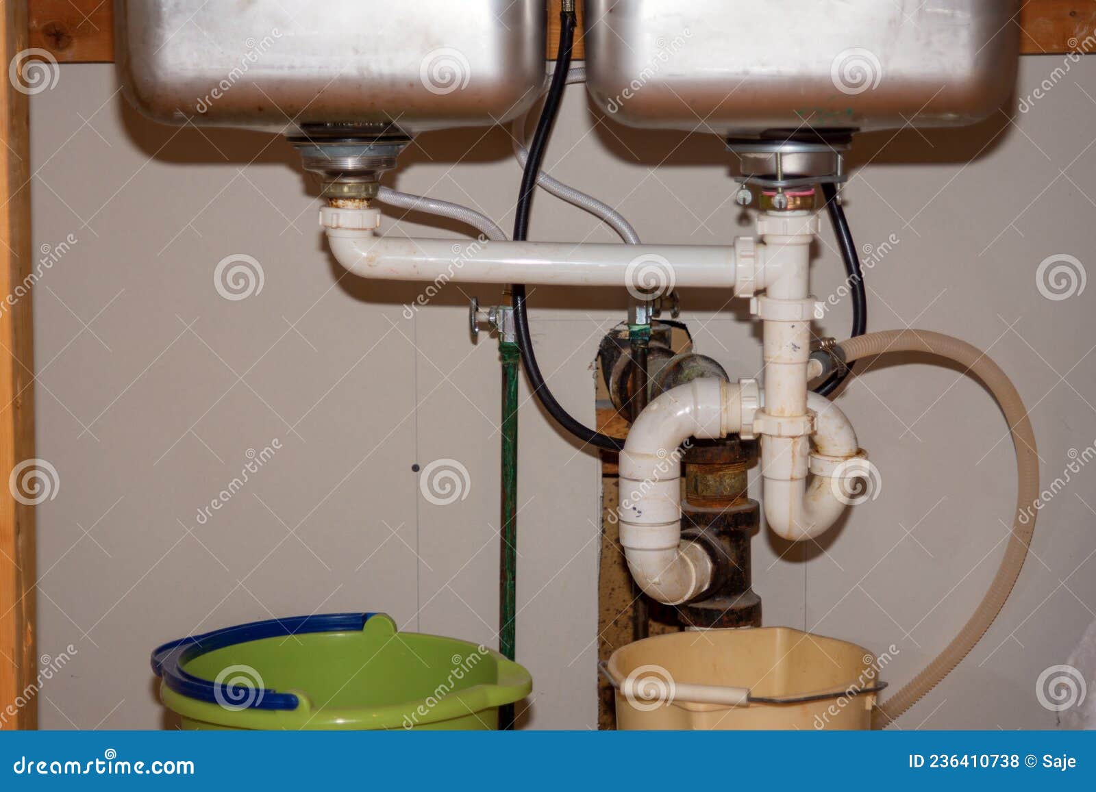 Kitchen Remodel Closeup of Under Sink Plumbing with Buckets Stock Photo