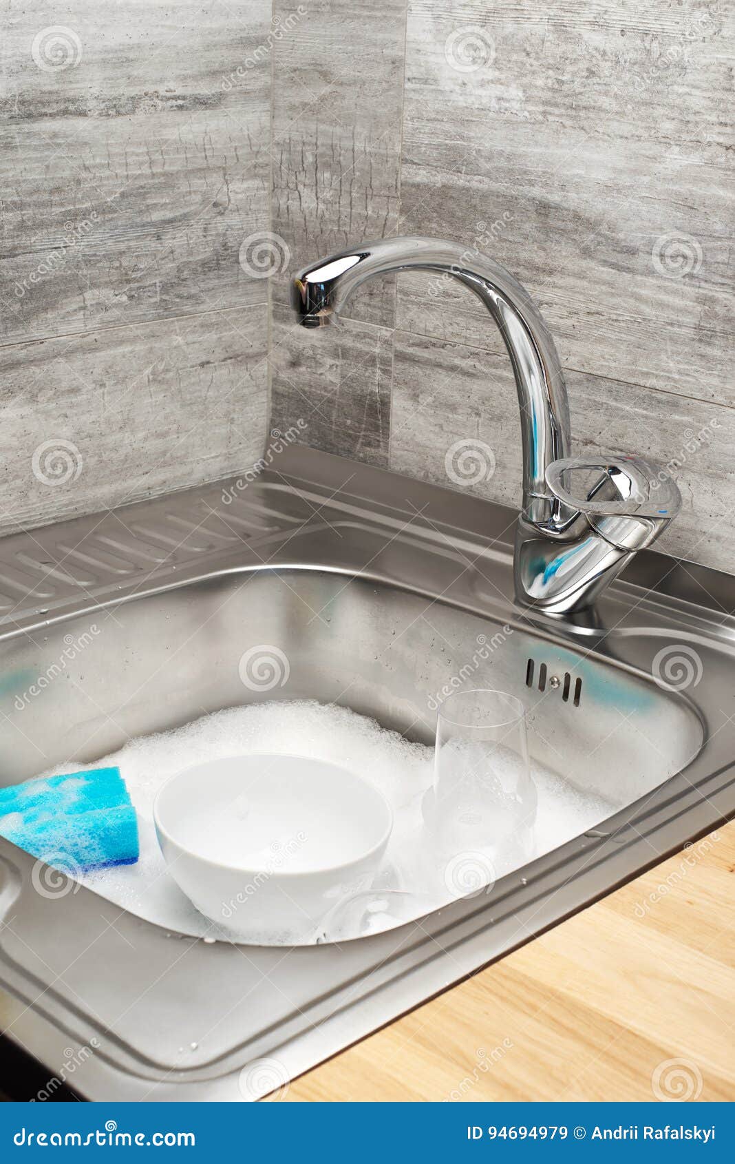 Kitchen Sink Full of Foam, Tableware and Blue Cleaning Sponge Stock