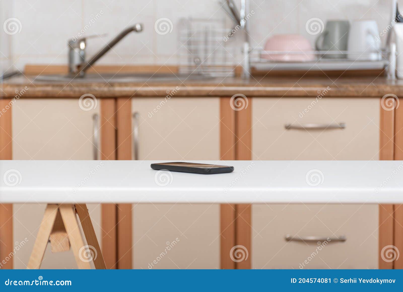 Kitchen Table and Mobile Phone on Kitchen Background.