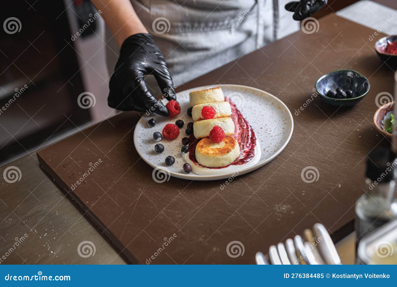 Kitchen Worker Decorated Ready Cheesecakes with Berries for Breakfast