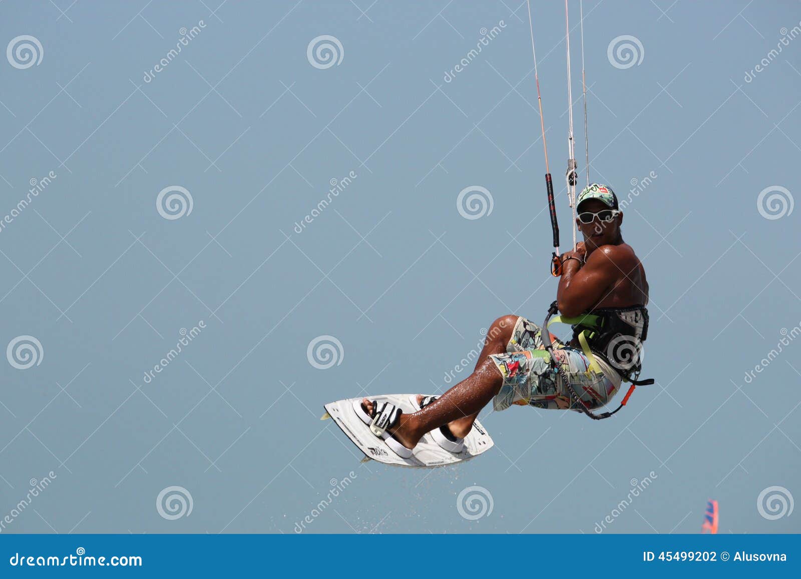 Kitesurfer. Enige vliegersurfer - de jonge mulatmensen in het glas vliegt in de lucht op de vliegerraad