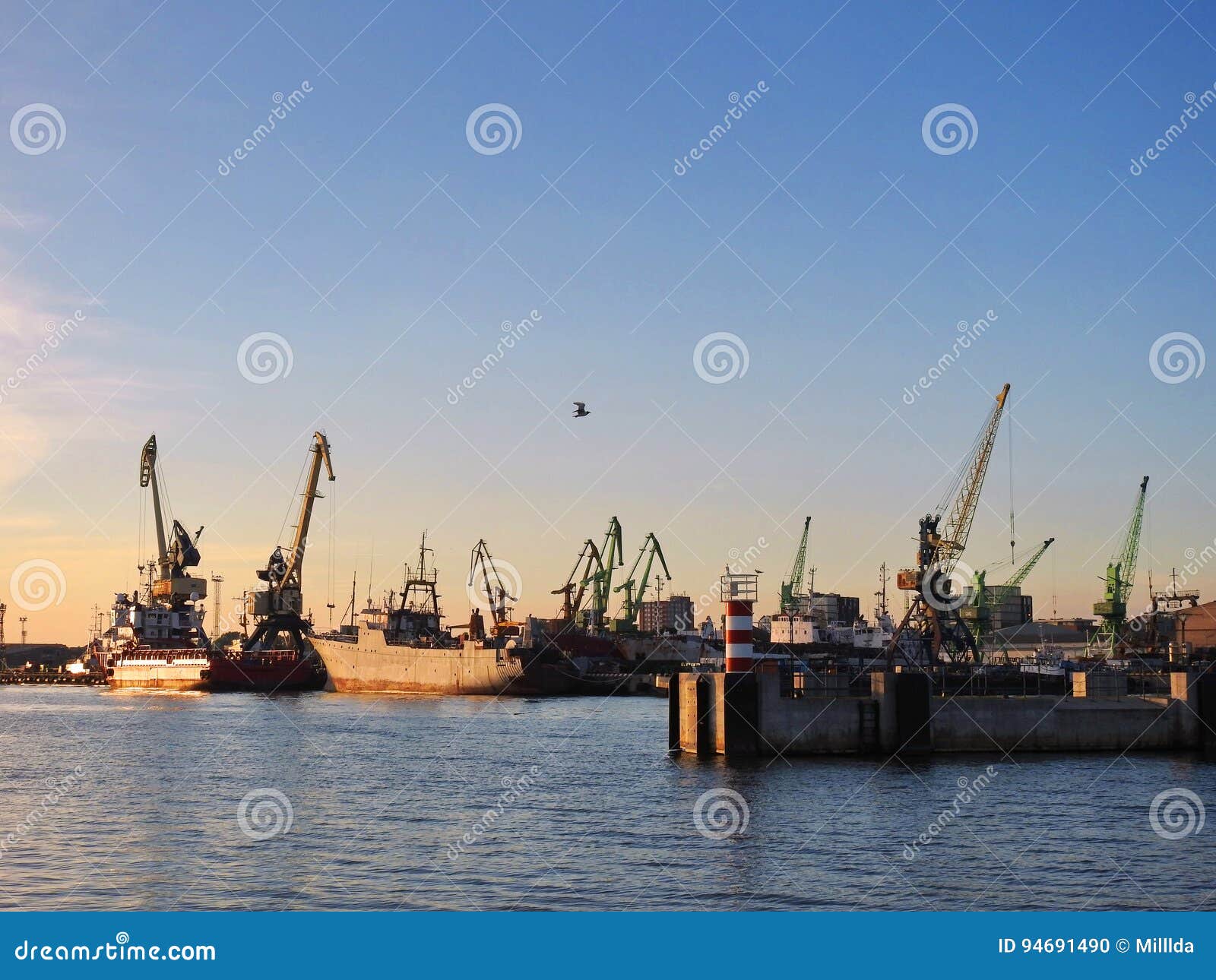 Klaipeda-Hafen, Litauen. Schiffe und Kräne in Klaipeda beherbergten in den Sonnenuntergangfarben, Litauen