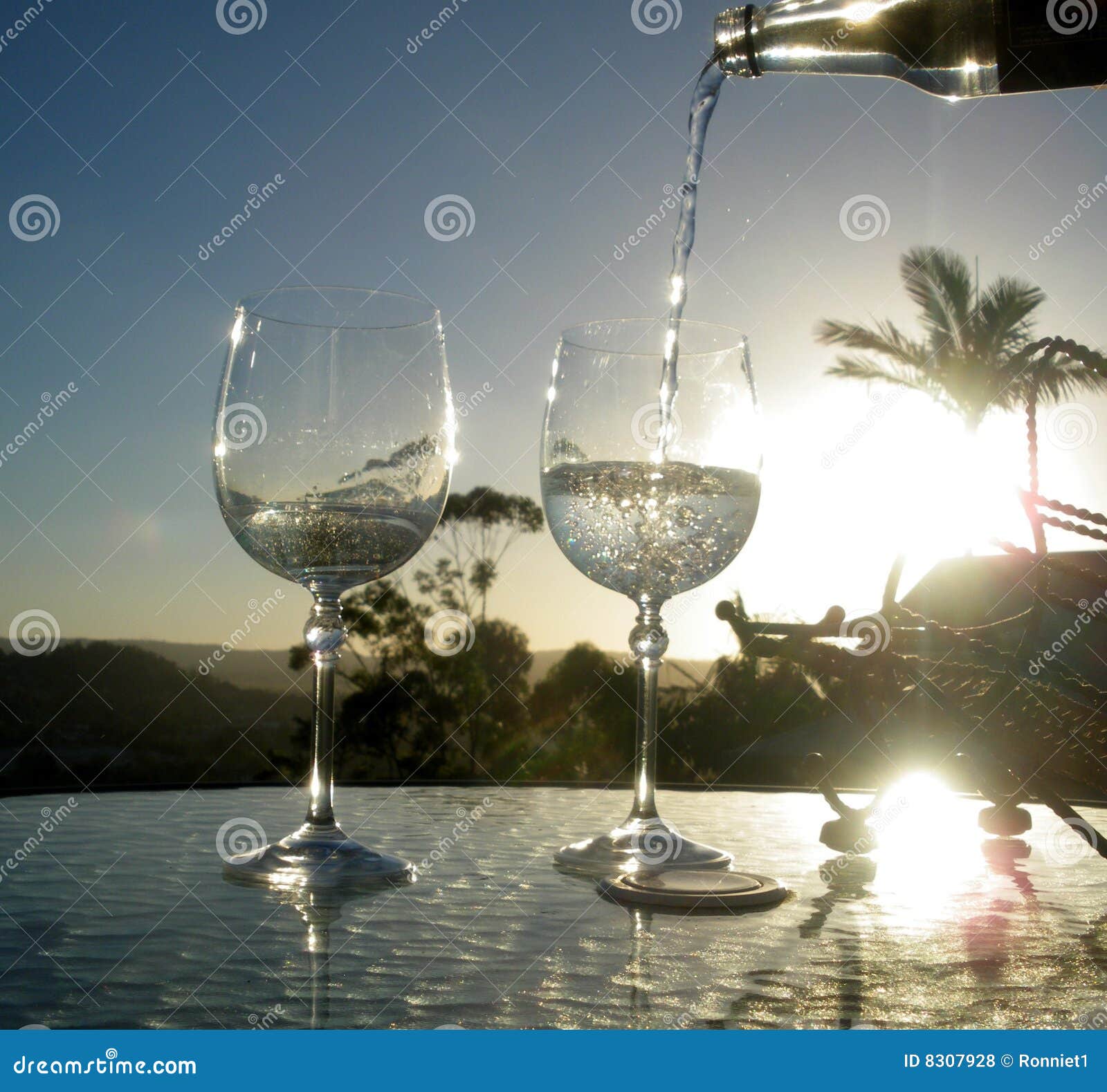 Klart crystal solnedgångvatten. Klara crystal drinkexponeringsglas som häller sparkling solnedgång två, water wine