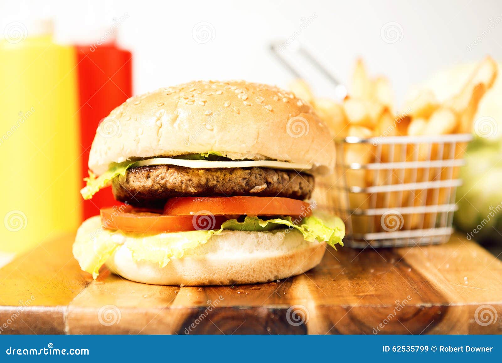 Klassisk hamburgare med ost. Hamburgare med ost, potatischiper och ingredienser på en vit bakgrund