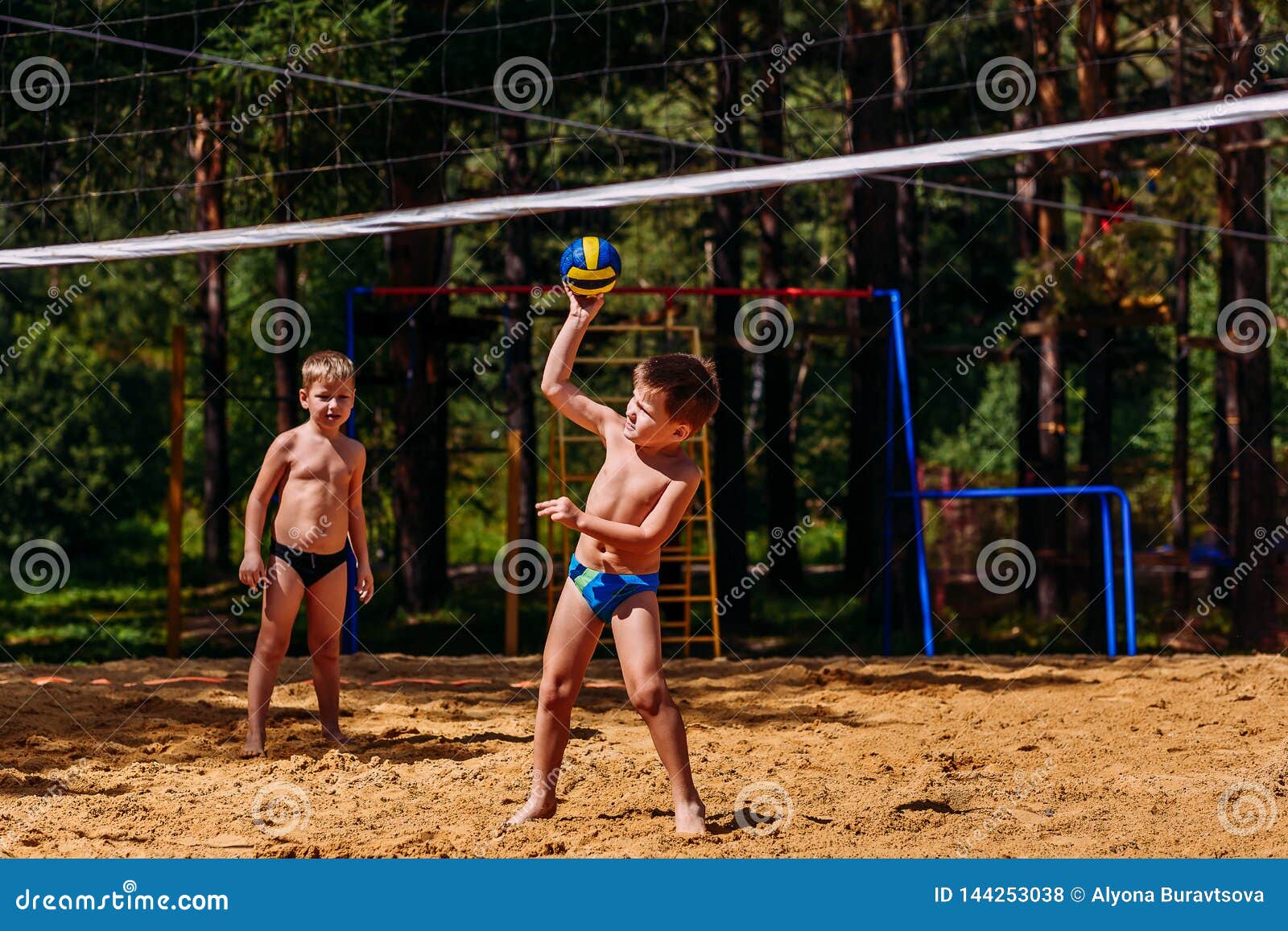 Kleine gelukkige kinderen die strandvolleyball spelen. Kleine gelukkige kinderen die strandvolleyball in de zomer spelen