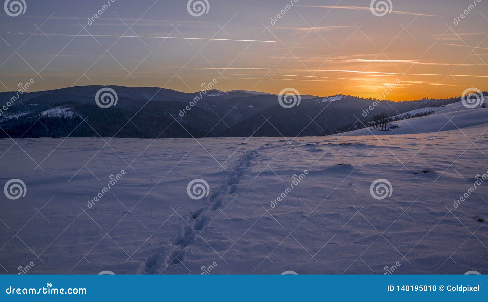 Kleine Stappen in de sneeuw. De zon gaat naar slaap en de kleine stappen blijft in de sneeuw