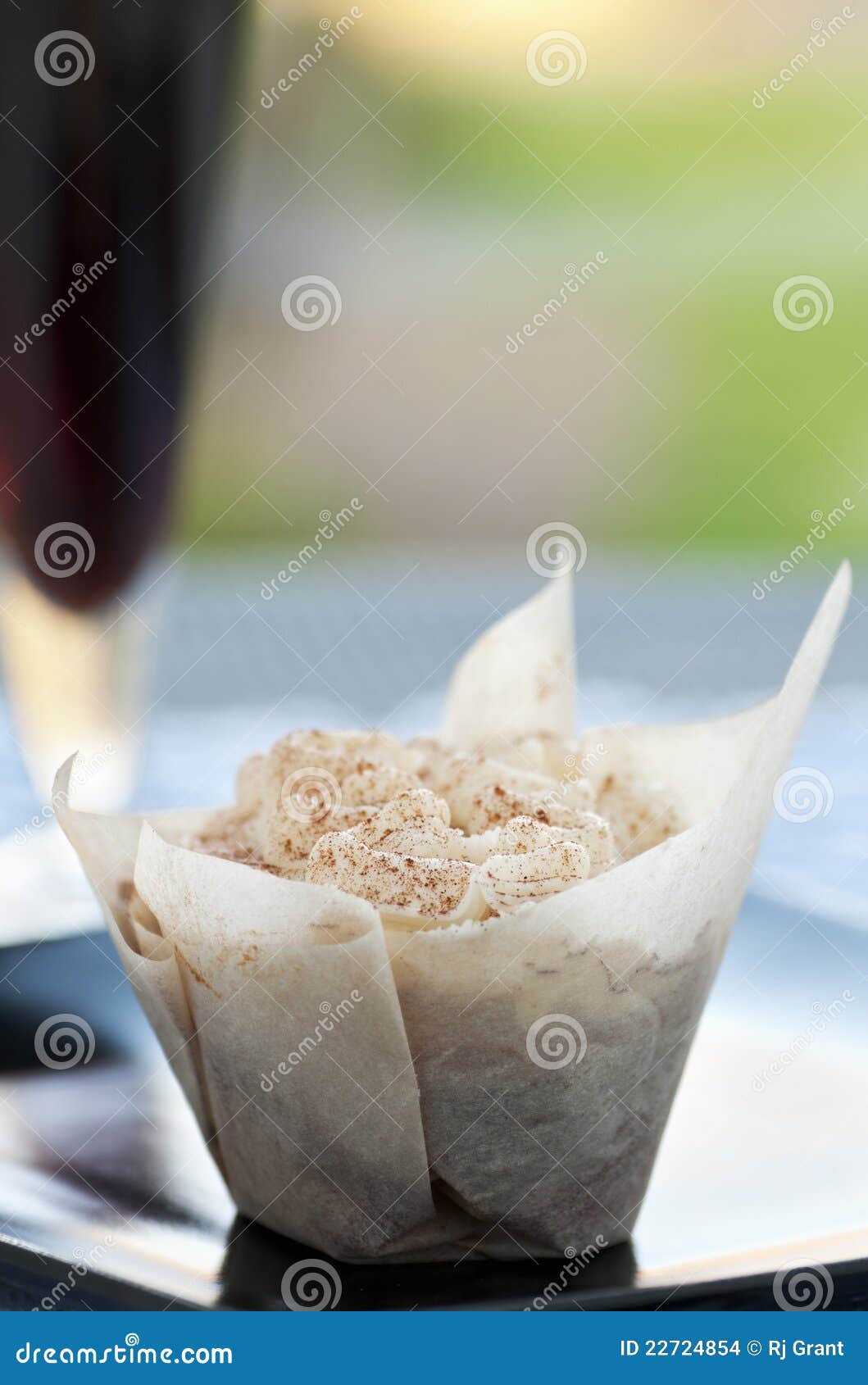 Kleiner Kuchen und Getränk. Frischer kleiner Kuchen mit buttercream und Glas dunkles Bier