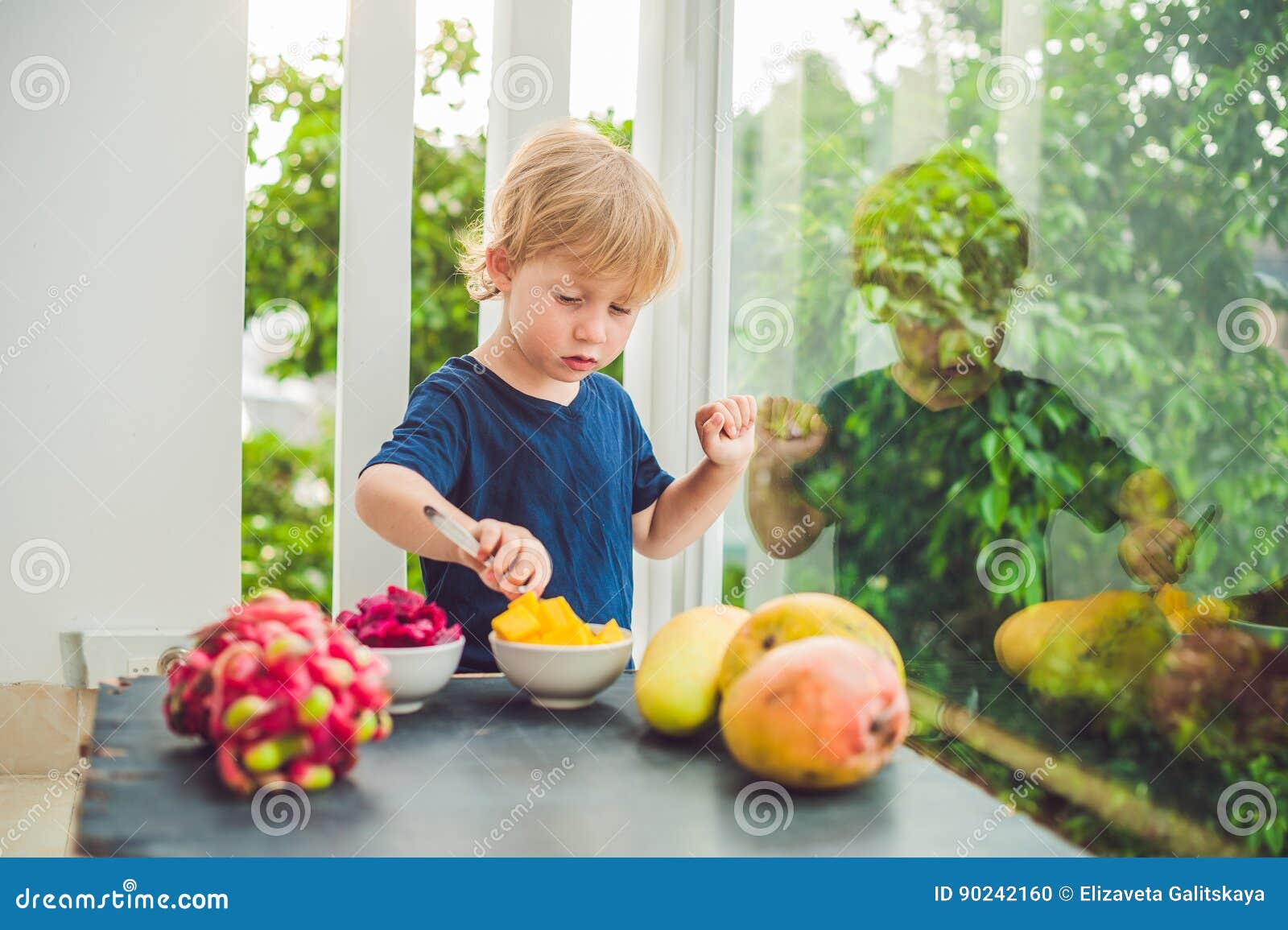 Kleiner Netter Junge, Der Mango Auf Der Terrasse Isst Stockfoto Bild