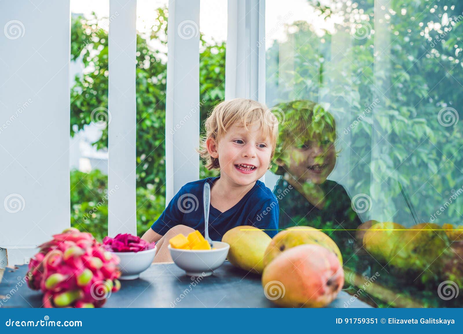 Kleiner Netter Junge, Der Mango Auf Der Terrasse Isst Stockbild Bild