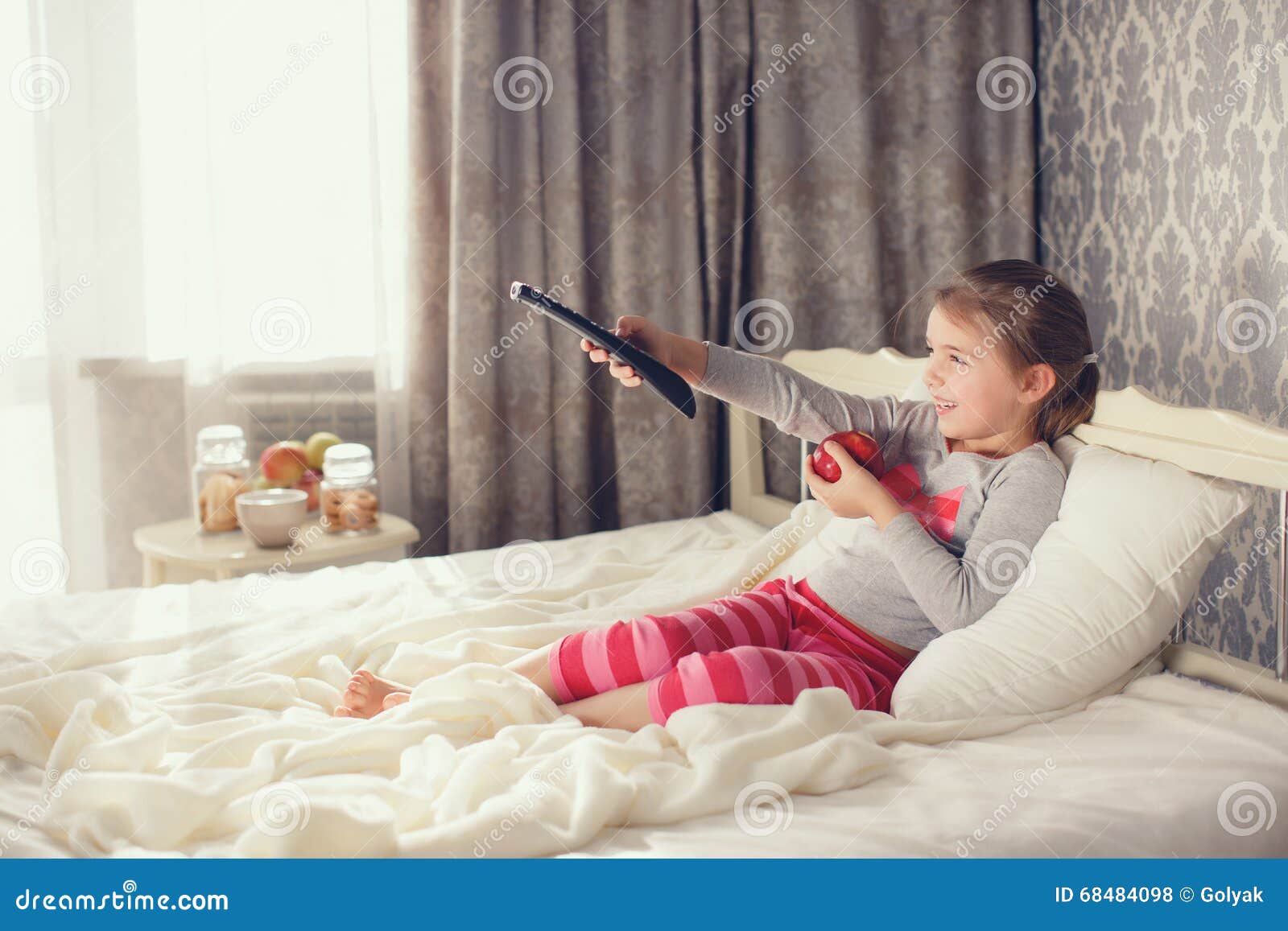 Kleines Madchen Das Im Bett Mit Einem Fernbedienung Fernsehen Liegt Stockfoto Bild Von Bett Fernbedienung