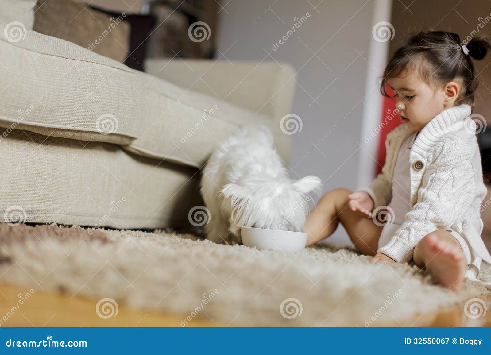 Kleines Mädchen mit einem Hund in einem Wohnzimmer