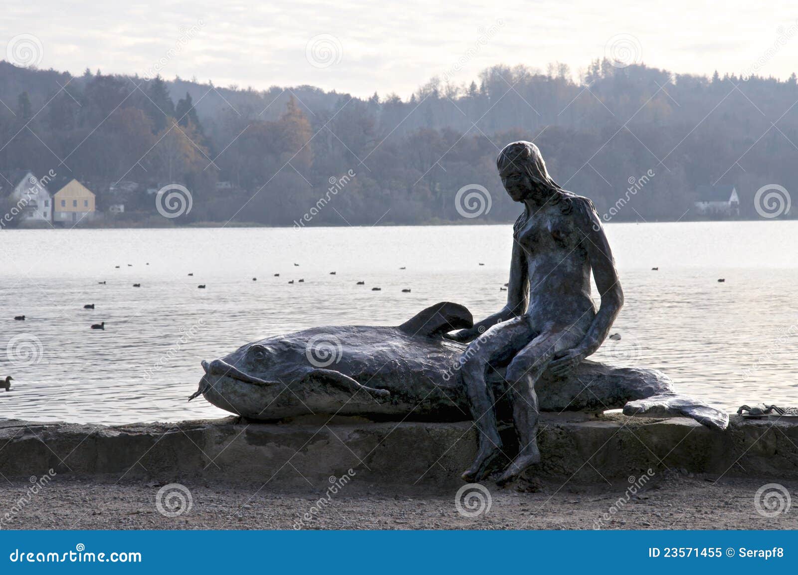 Kleines Mädchen mit einem Wels. Eine freundliche Skulptur nahe Ammersee im Bayern, Deutschland.