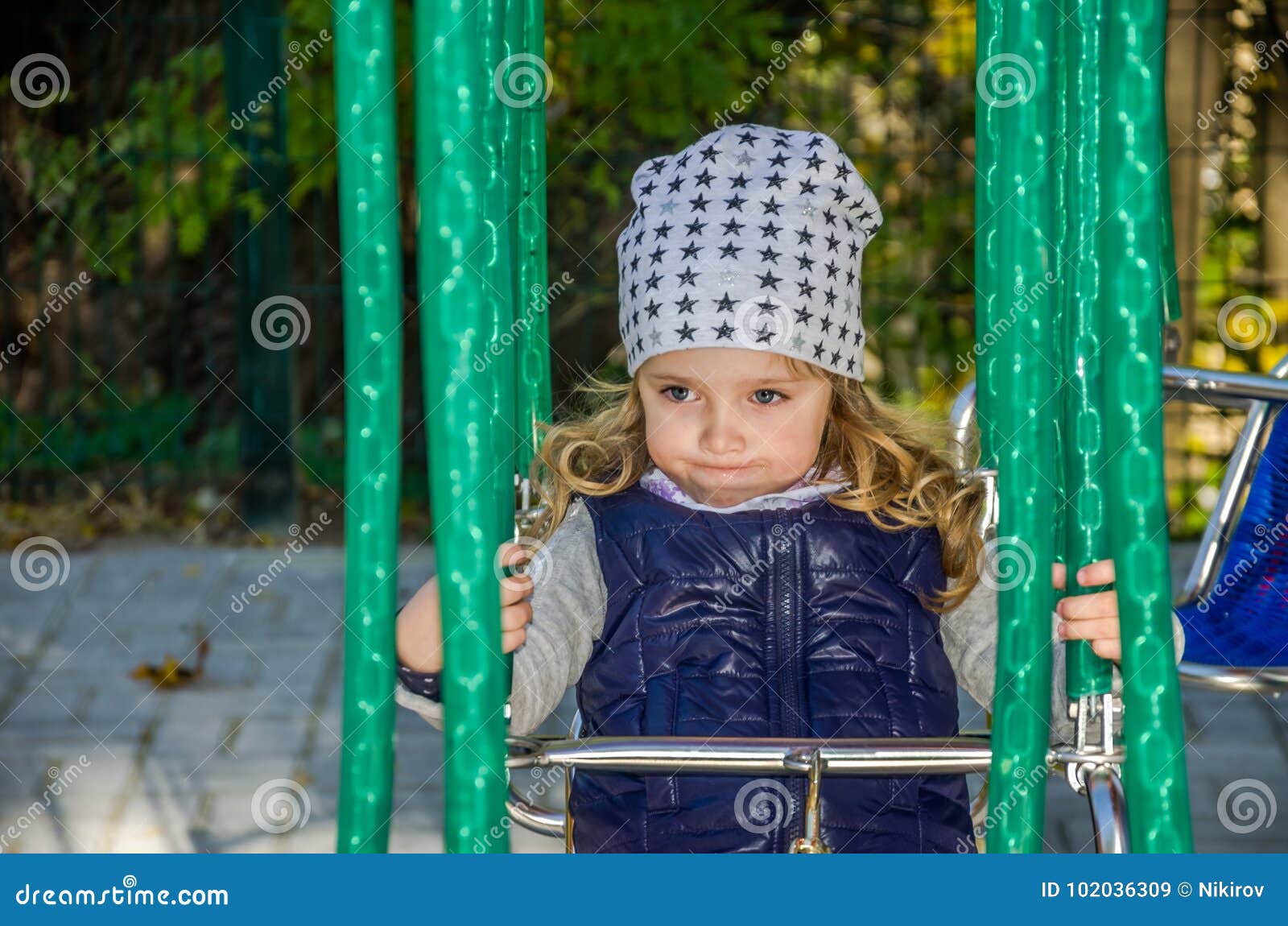 Kleines reizend Mädchen fährt auf ein Kettenkarussell in einem Vergnügungspark