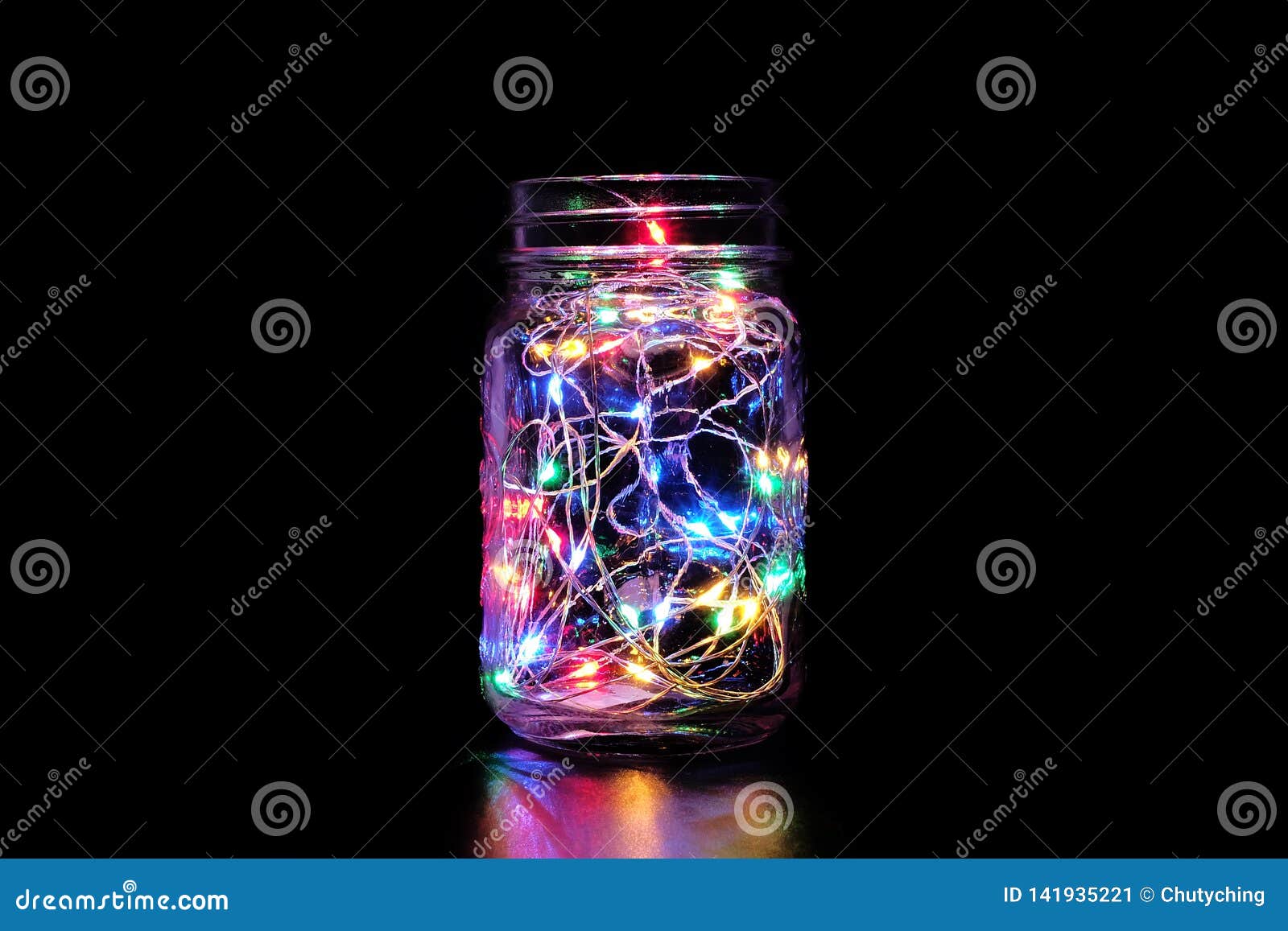 Kleurrijk Feelicht in Mason Jar. Kleurrijk feelicht/koordlicht in metselaarkruik op zwarte achtergrond Rustige fotografie Perfect als Kerstmisdecoratie