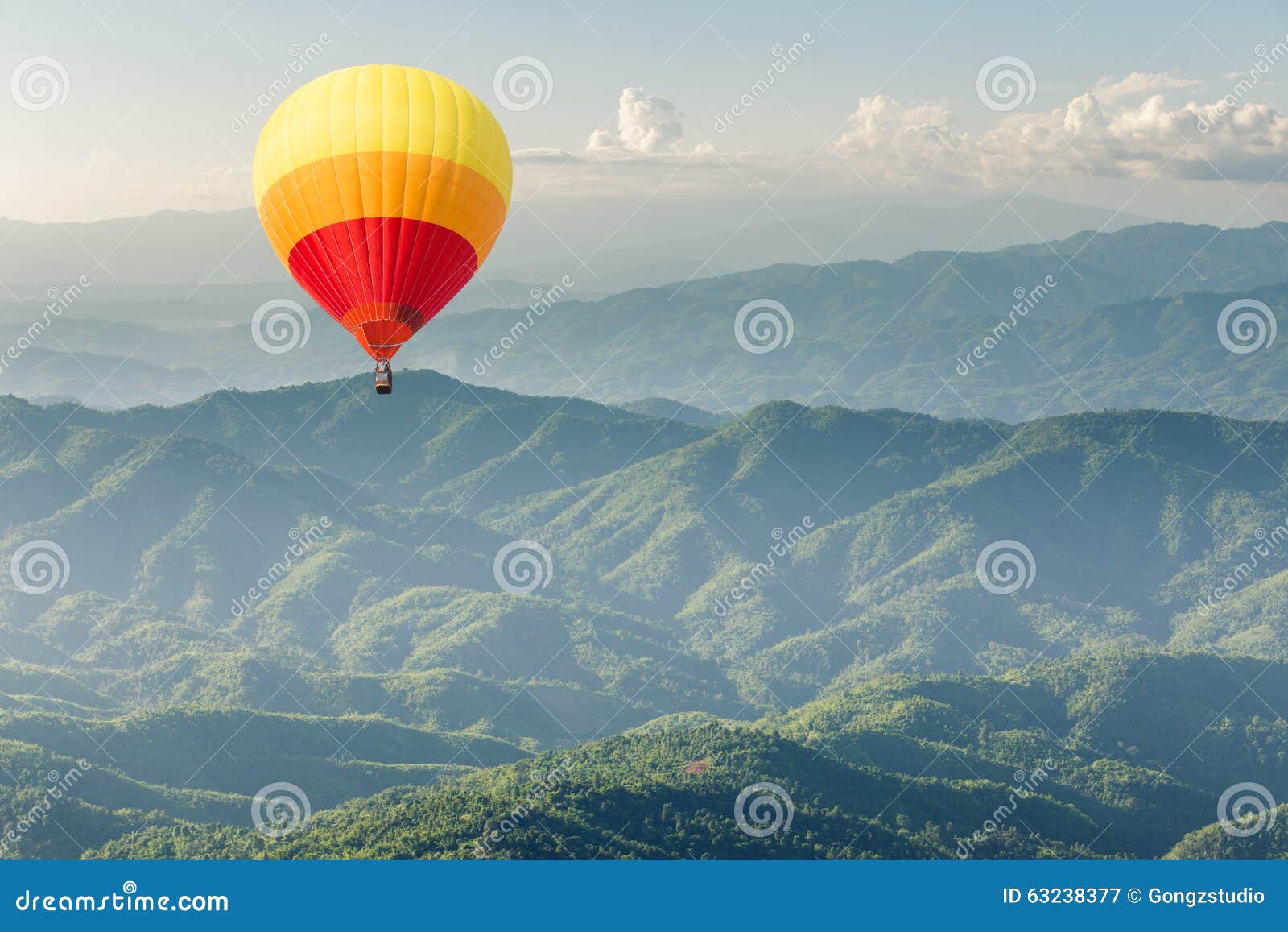 Kleurrijke hete luchtballon boven groene bosberg