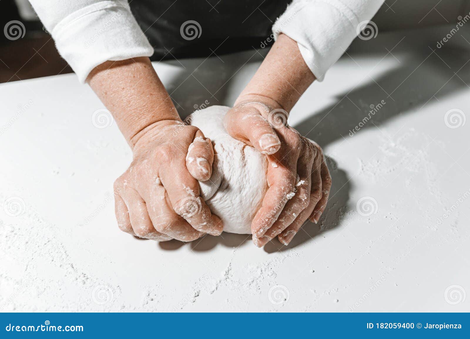 Kneading and Preparing the Dough by Woman`s Hands on the Table Stock