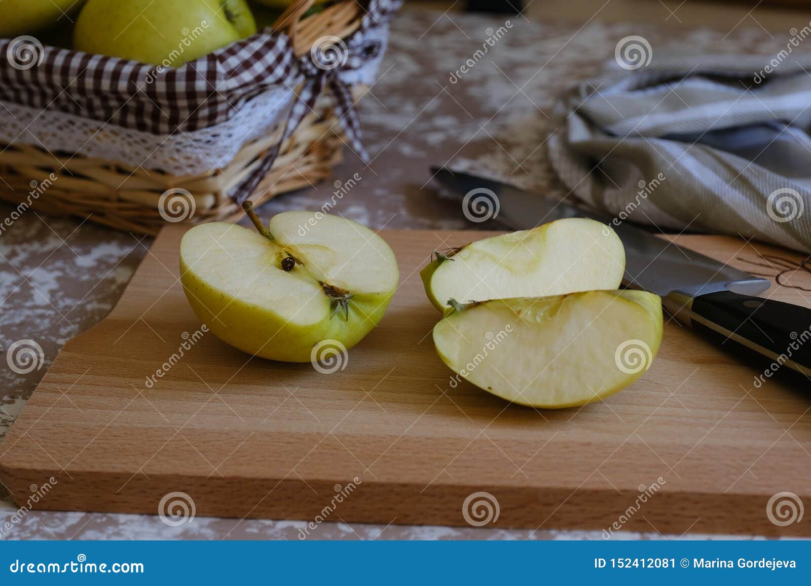 knife and apple on a cutting board on a table in the kitchen. chantecler apples