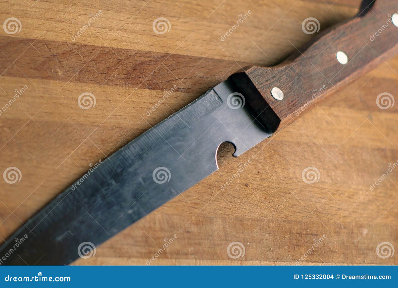 Knife with a Wooden Handle on a Rustic Kitchen Cutting Board Stock