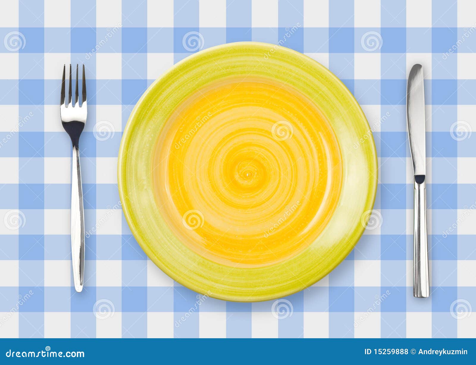 knife, yellow plate and fork on checked top view